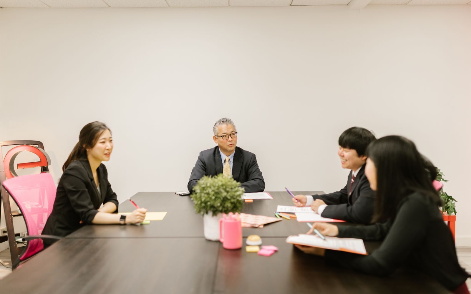 会議室でチームメンバーが問い合わせ対応の資料を確認しながら打ち合わせをしている様子
